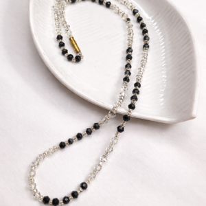 Handmade Classic Noir Necklace by Beads By Nasreen viewed from above on a white leaf-shaped ceramic tray.