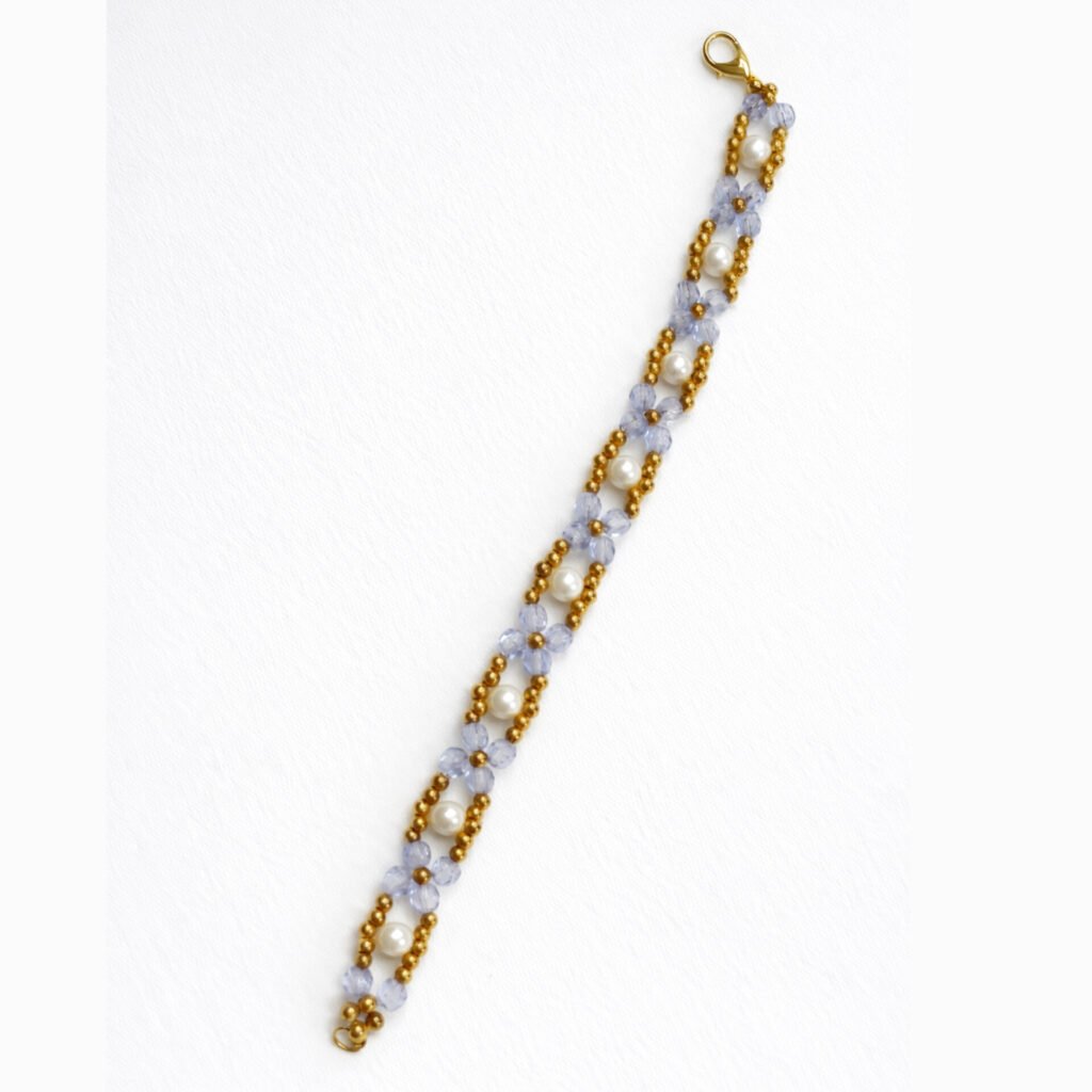 Handmade Aqua Bloom Bead Bracelet by Beads By Nasreen featuring a single strand of blue floral beadwork and white pearls with a gold lobster clasp.