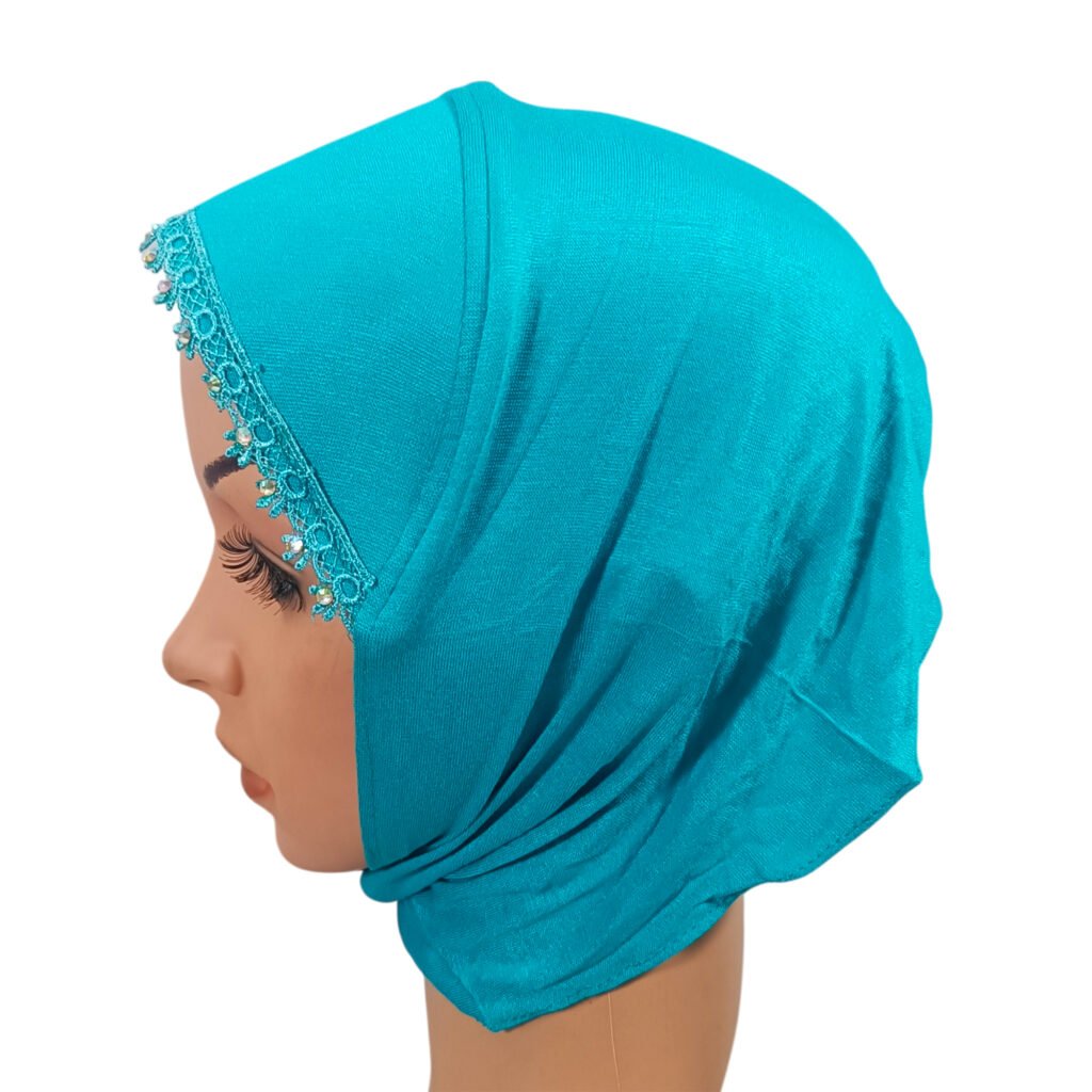 A side profile view of a mannequin wearing a vibrant turquoise Canvas Ninja Cap featuring detailed rhinestone lace trim along the front opening and a streamlined, lightweight design that leaves the neck clear.