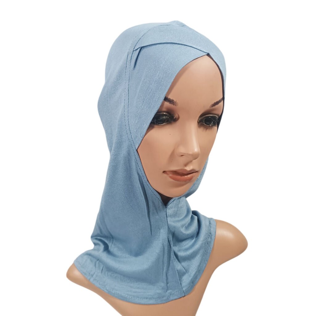 A side profile view of a mannequin wearing a light smoky blue NINJA CRISS CROSS Under Scarf demonstrating the tailored head and neck coverage.