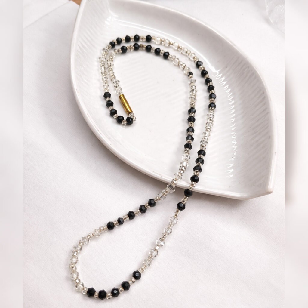 Handmade Classic Noir Necklace by Beads By Nasreen viewed from above on a white leaf-shaped ceramic tray.