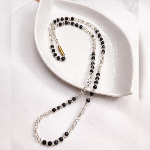 Handmade Classic Noir Necklace by Beads By Nasreen viewed from above on a white leaf-shaped ceramic tray.