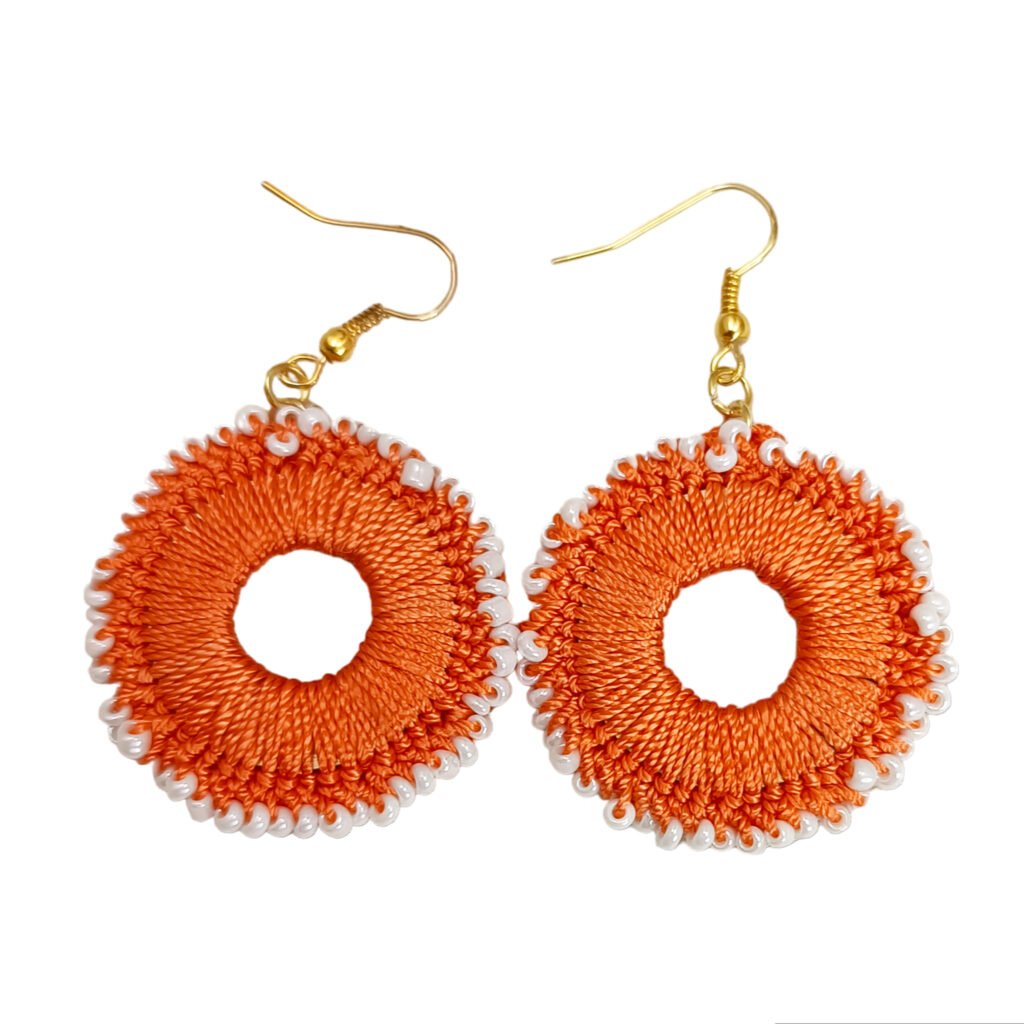 A matching pair of handmade Eva Earring Crochet Jewelry dangles featuring a circular woven thread design with a delicate white seed bead outer border.